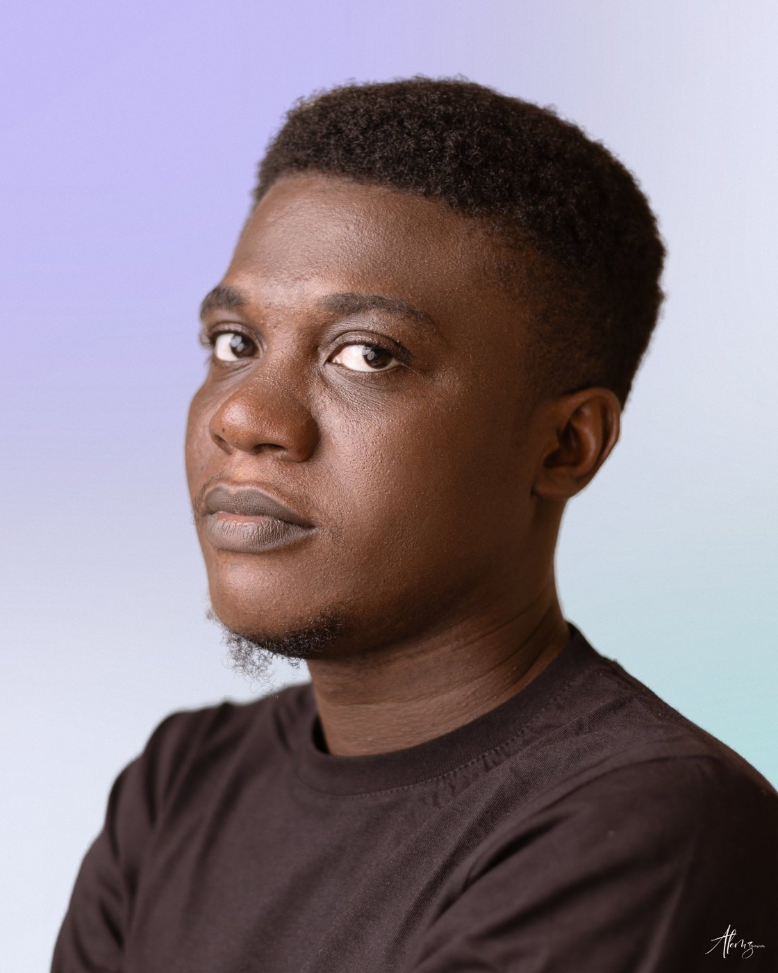Moses Afolabi in a dark t-shirt, looking towards the camera